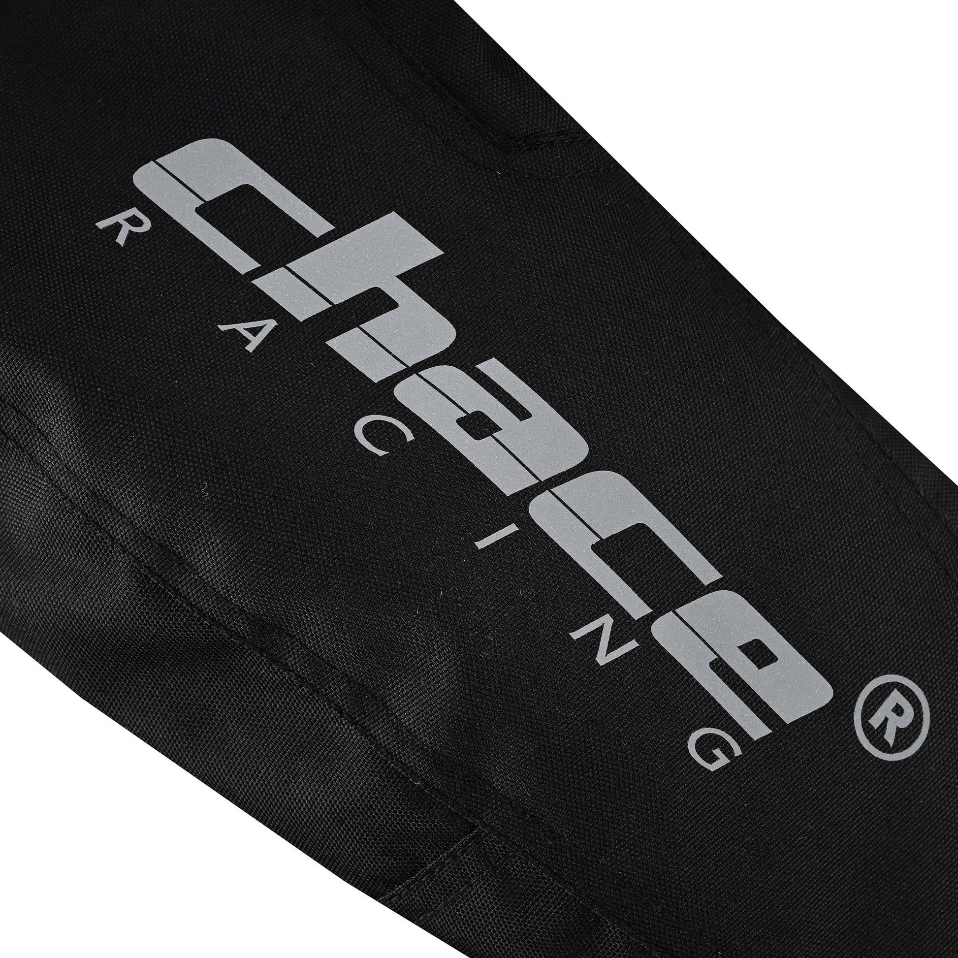 Extreme close-up of the jacket sleeve showcasing a large, stylized, reflective gray "Chace Racing" logo print on the black textile fabric.