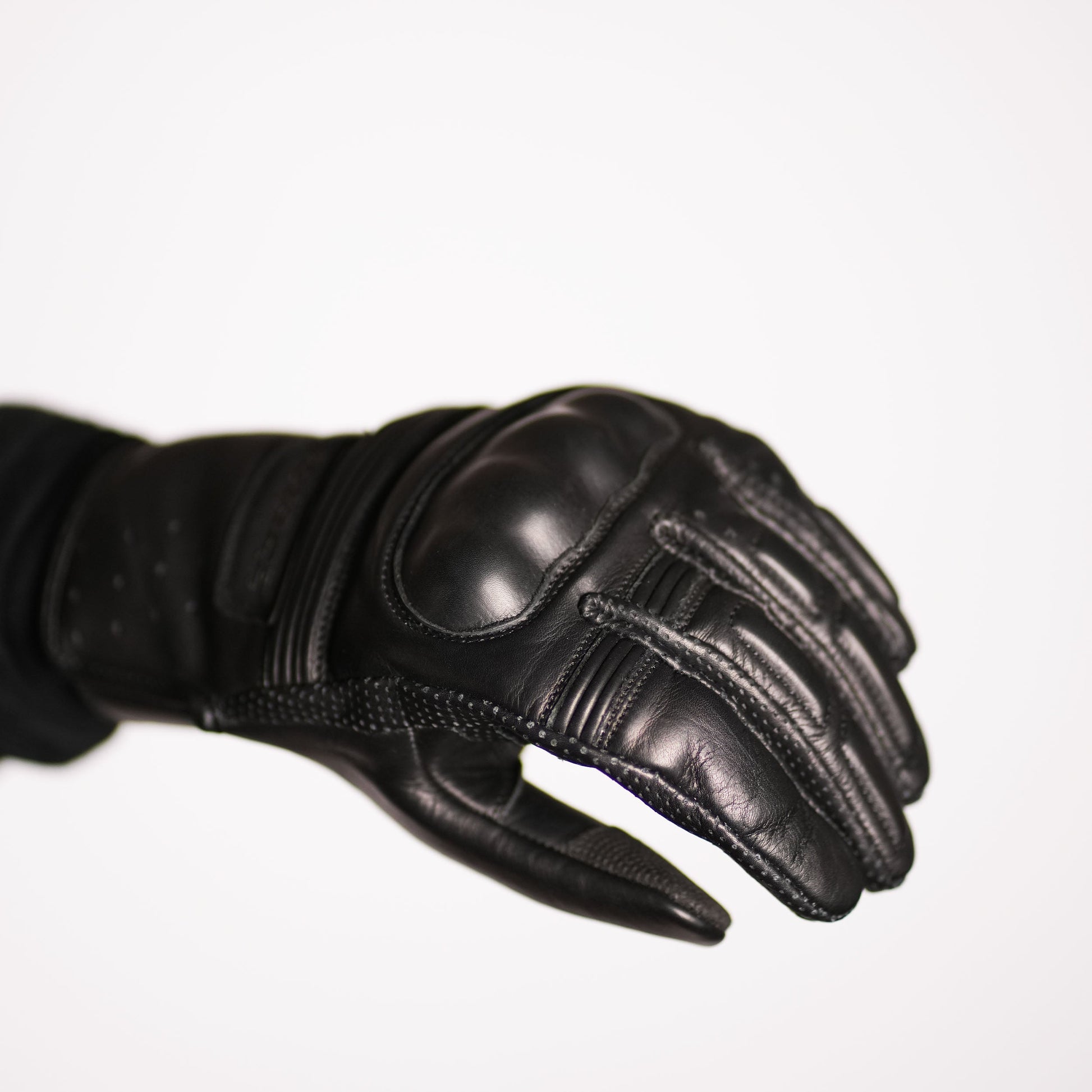 Profile view of the hand in the glove, showcasing the smooth palm leather and the protective, reinforced back of the hand with the hard knuckle armor.