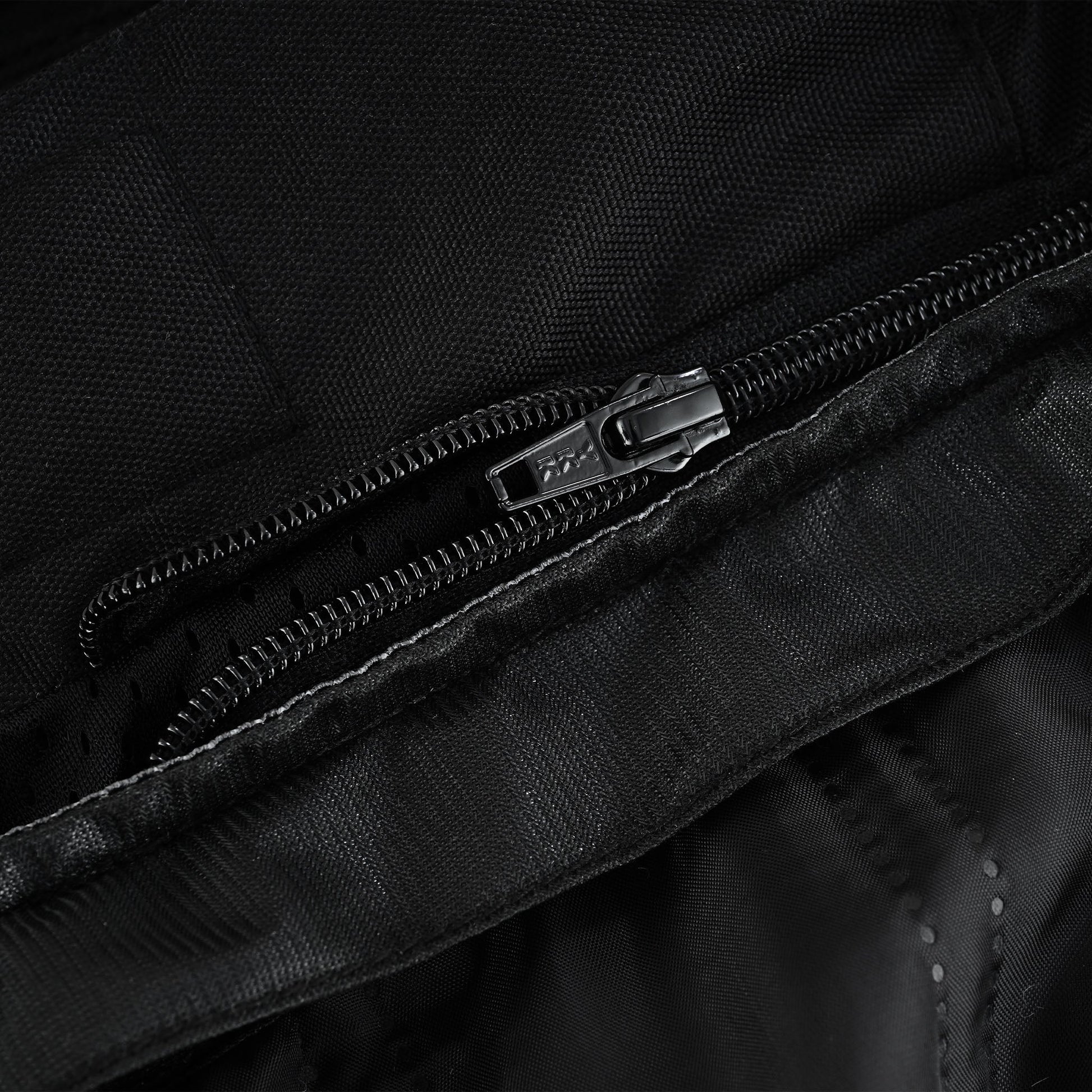 Close-up of the trousers' waist interior, showing the internal zipper track used for attaching the removable thermal or waterproof lining.