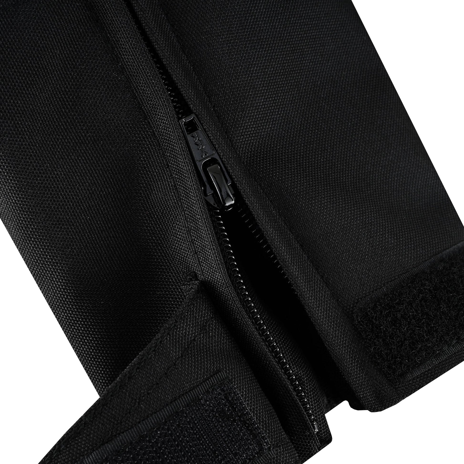 Extreme close-up of the jacket's internal textile, showing the black zipper used to attach the removable liner, and adjacent hook-and-loop (Velcro) material for secure closure.