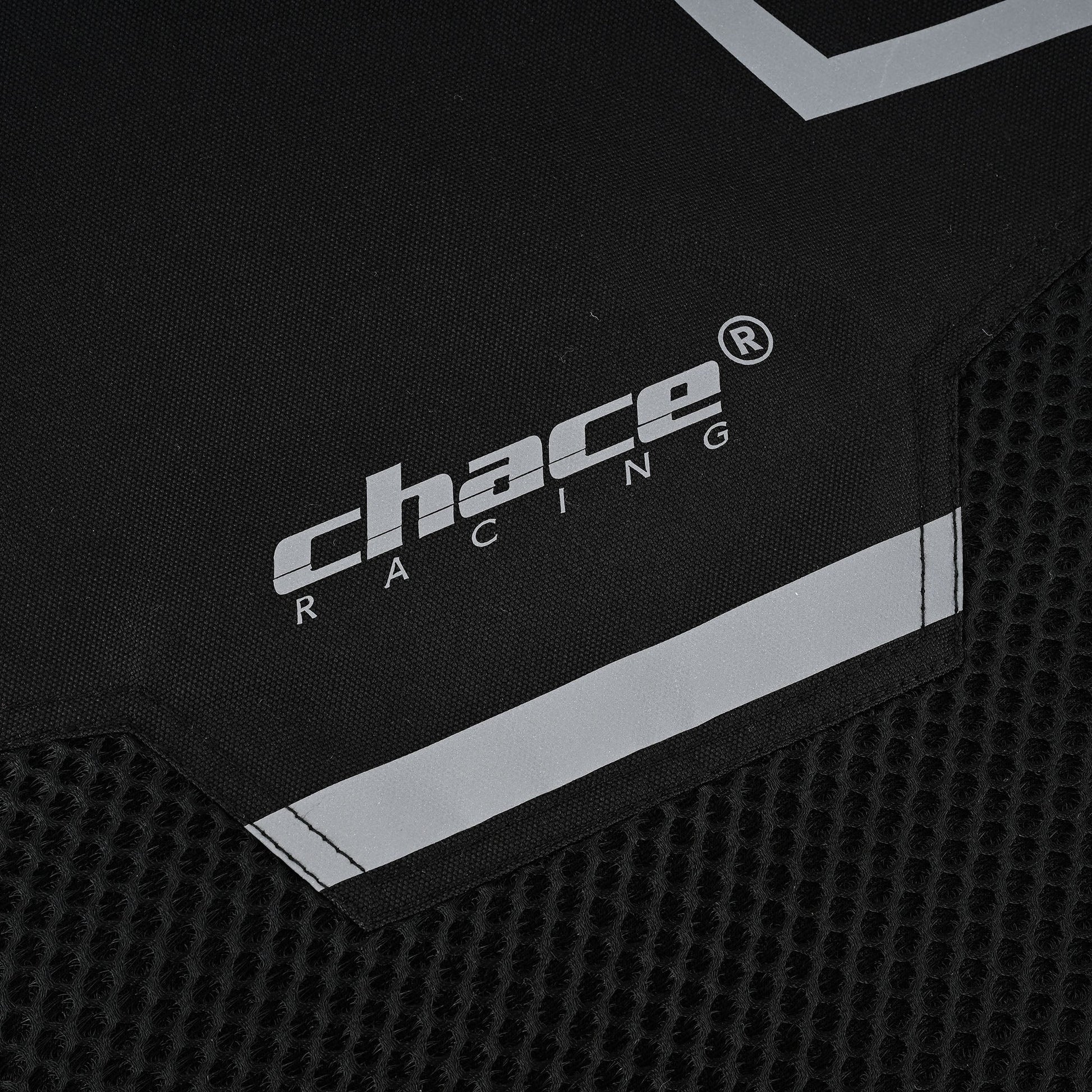 Close-up of the lower front portion of the jacket, showing the transition from the textile material to the hexagonal mesh panel, along with the "Chace Racing" logo and a reflective strip.